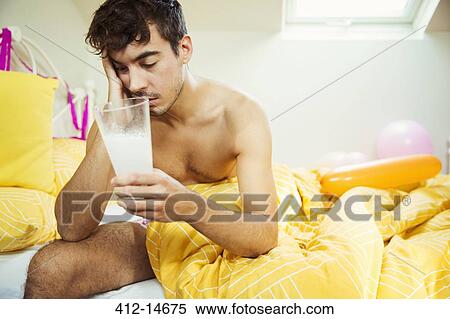 Hungover man drinking concoction in bed the morning after a party View Large Photo Image Stock Photography - Hungover man drinking concoction in bed the morning after a party. Fotosearch