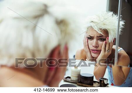 Hungover woman examining herself in mirror View Large Photo Image Stock Photo - Hungover woman examining herself in mirror. Fotosearch