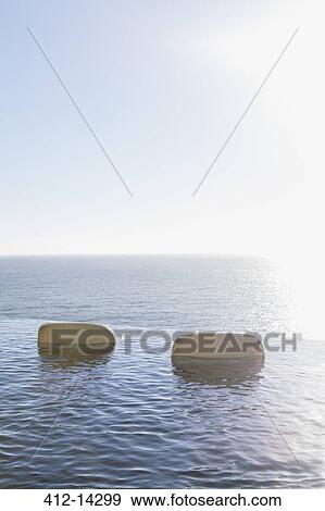 Lawn chairs in infinity pool overlooking ocean View Large Photo Image Stock Photo - Lawn chairs in infinity pool overlooking ocean. Fotosearch