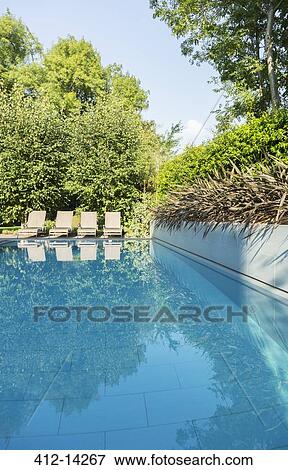 Stock Photo - Lounge chairs by swimming pool. Fotosearch