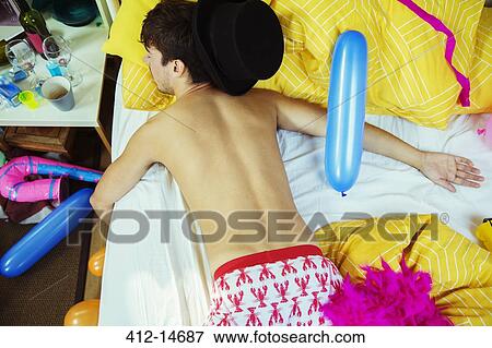 Man sleeping on bed after party View Large Photo Image Stock Photo - Man sleeping on bed after party. Fotosearch