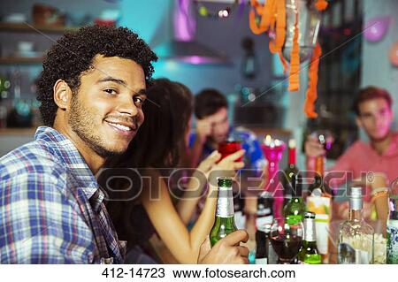 Stock Image - Man smiling at party. Fotosearch