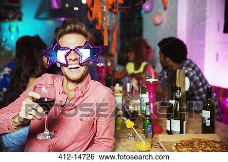 Stock Photograph - Man wearing oversized sunglasses at party. Fotosearch