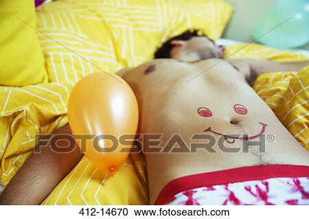 Man with smiley face drawing on belly sleeping after party View Large Photo Image Stock Image - Man with smiley face drawing on belly sleeping after party. Fotosearch