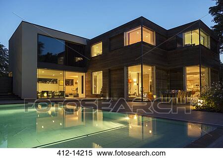 Modern house and swimming pool illuminated at dusk View Large Photo Image Stock Photography - Modern house and swimming pool illuminated at dusk. Fotosearch