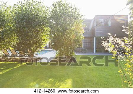 Modern house overlooking sunny backyard View Large Photo Image Stock Image - Modern house overlooking sunny backyard. Fotosearch