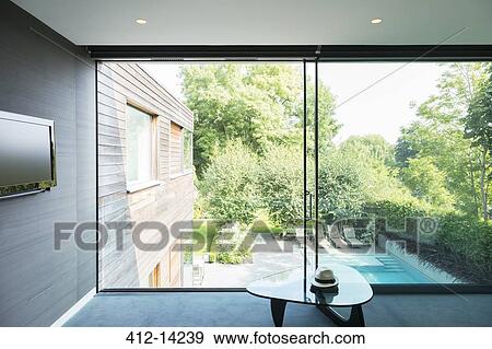 Stock Photo - Modern house overlooking swimming pool. Fotosearch