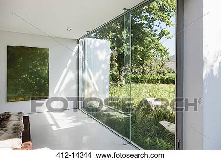 Picture - Modern house with glass walls overlooking grass. Fotosearch