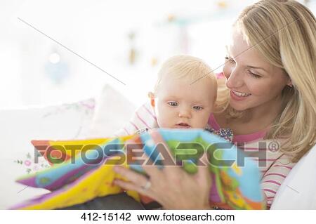 Mother reading to baby girl on sofa View Large Photo Image Stock Image - Mother reading to baby girl on sofa. Fotosearch