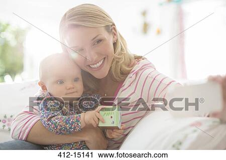 Mother taking self-portrait with baby girl View Large Photo Image Stock Image - Mother taking self-portrait with baby girl. Fotosearch