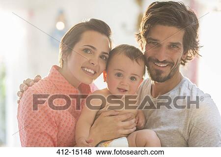 Stock Photo - Parents smiling with baby boy. Fotosearch