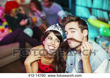Smiling couple playing together at party View Large Photo Image Stock Image - Smiling couple playing together at party. Fotosearch