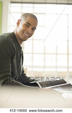 Smiling man reading magazine View Large Photo Image Stock Photography - Smiling man reading magazine. Fotosearch