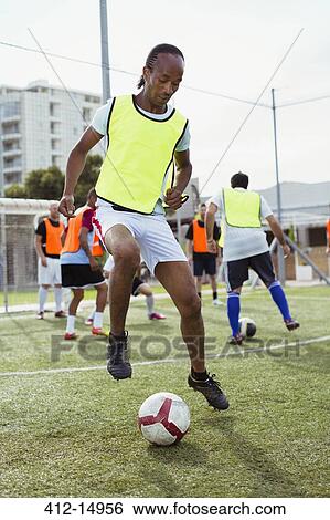 Stock Photograph - Soccer player training on field. Fotosearch