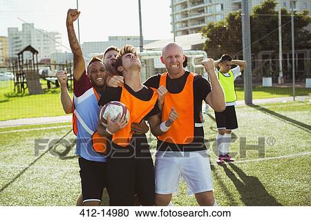 Stock Image - Soccer players cheering on field. Fotosearch