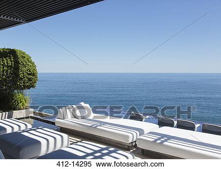Stock Photography - Sofas and infinity pool overlooking ocean. Fotosearch