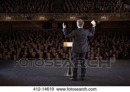 Speaker gesturing on stage in theater View Large Photo Image Stock Photo - Speaker gesturing on stage in theater. Fotosearch