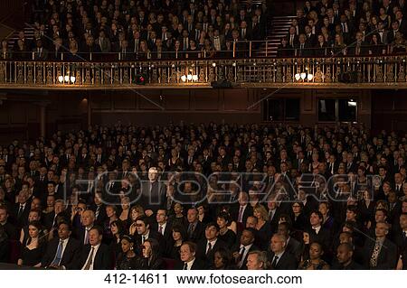 Stock Image - Spotlight on audience members in theater. Fotosearch