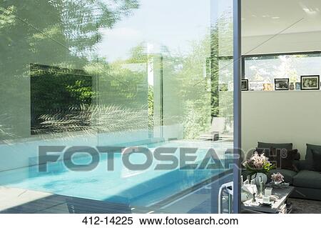 Swimming pool reflected in glass windows of modern house View Large Photo Image Stock Photography - Swimming pool reflected in glass windows of modern house. Fotosearch