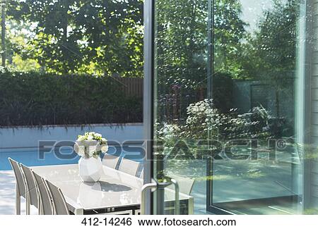 Stock Photograph - Table and chairs by swimming pool. Fotosearch
