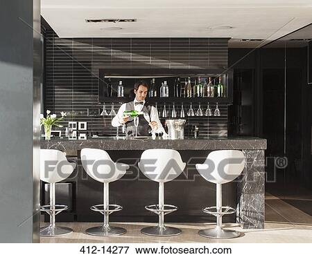 Stock Photo - Waiter making drinks in bar. Fotosearch