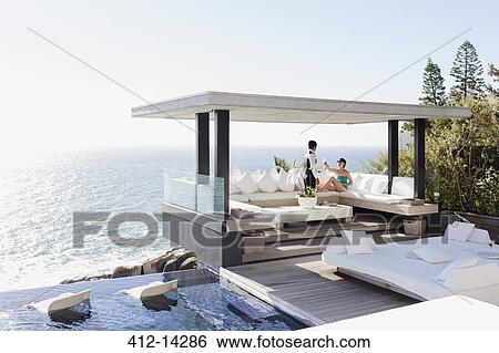 Waiter serving woman drinks at cabana overlooking ocean View Large Photo Image Stock Photograph - Waiter serving woman drinks at cabana overlooking ocean. Fotosearch