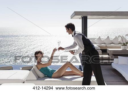 Picture - Waiter serving woman drinks outdoors. Fotosearch