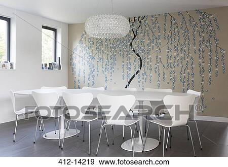 Stock Photo - Wall art and chandelier in modern dining room. Fotosearch