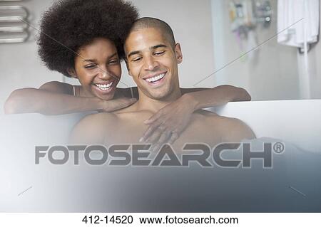 Stock Image - Woman hugging boyfriend in bath. Fotosearch