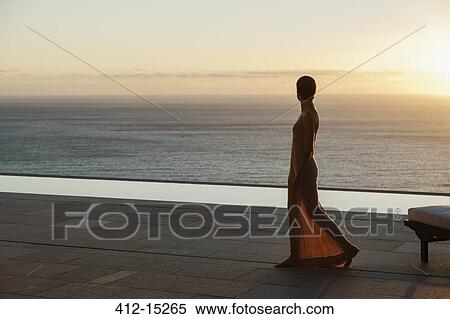 Woman looking at ocean from modern patio at sunset View Large Photo Image Stock Photography - Woman looking at ocean from modern patio at sunset. Fotosearch