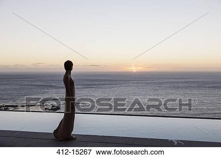 Stock Photo - Woman looking at ocean from patio. Fotosearch