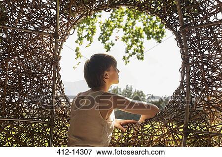 Woman looking out window of nest tree house View Large Photo Image Stock Photo - Woman looking out window of nest tree house. Fotosearch