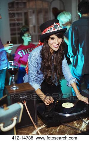 Stock Photo - Woman playing records at party. Fotosearch