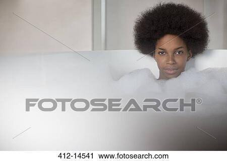 Stock Image - Woman relaxing in bath. Fotosearch