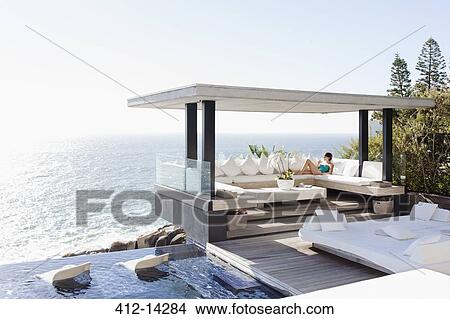 Picture - Woman relaxing in cabana overlooking ocean. Fotosearch