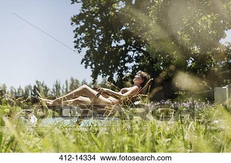 Woman relaxing in lounge chair outdoors View Large Photo Image Picture - Woman relaxing in lounge chair outdoors. Fotosearch
