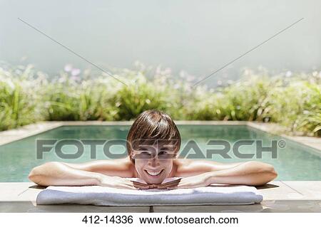 Stock Photograph - Woman relaxing in luxury lap pool. Fotosearch