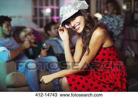 Woman sitting in living room at party View Large Photo Image Stock Image - Woman sitting in living room at party. Fotosearch