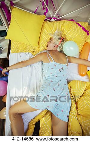 Woman sleeping on bed after party View Large Photo Image Stock Photograph - Woman sleeping on bed after party. Fotosearch
