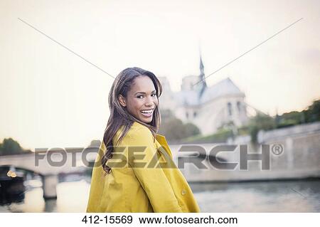 Woman smiling along Seine River near Notre Dame Cathedral, Paris, France View Large Photo Image Stock Photo - Woman smiling along Seine River near Notre Dame Cathedral, Paris, France. Fotosearch