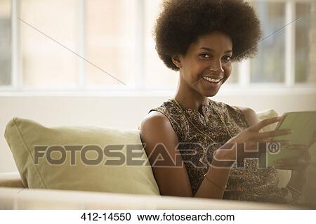 Woman using digital tablet on sofa View Large Photo Image Stock Image - Woman using digital tablet on sofa. Fotosearch