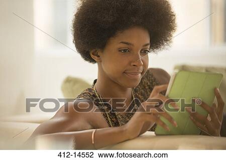 Woman using digital tablet on sofa View Large Photo Image Stock Image - Woman using digital tablet on sofa. Fotosearch