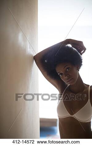 Stock Image - Woman wearing bra in corridor. Fotosearch