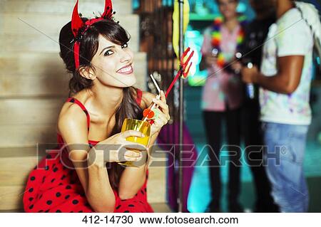 Woman wearing devil costume at party View Large Photo Image Stock Image - Woman wearing devil costume at party. Fotosearch
