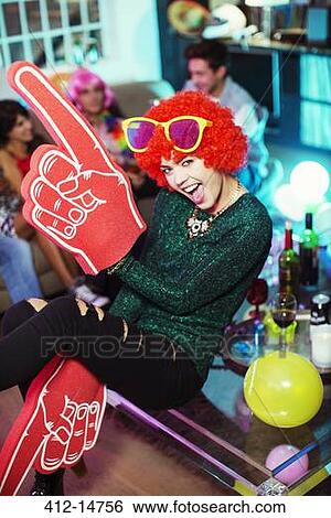 Woman wearing wig, oversized sunglasses and foam finger View Large Photo Image Stock Photograph - Woman wearing wig, oversized sunglasses and foam finger. Fotosearch