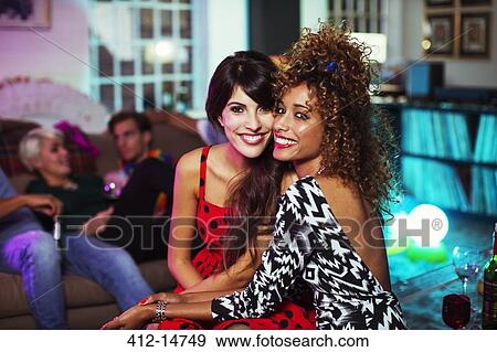 Women hugging in living room at party View Large Photo Image Stock Photo - Women hugging in living room at party. Fotosearch