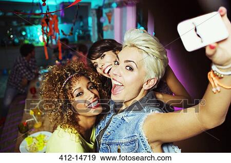 Stock Photo - Women taking self-portrait at party. Fotosearch