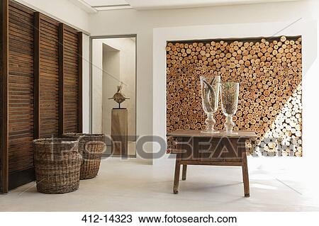 Stock Image - Wood logs in wall and table in modern foyer. Fotosearch