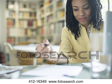 Businesswoman with paperwork at laptop View Large Photo Image Stock Photo - Businesswoman with paperwork at laptop. Fotosearch