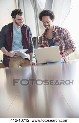 Casual businessmen using laptop in meeting View Large Photo Image Stock Image - Casual businessmen using laptop in meeting. Fotosearch